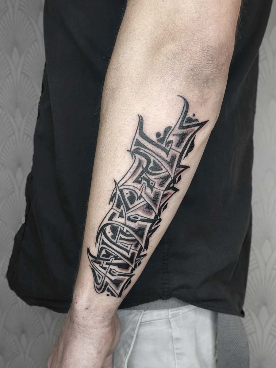 Aurel-Tattoo-Schriftzug-im-Graffiti-Stil.-Tätowierung-in-Schwarz-auf-dem-Unterarm.