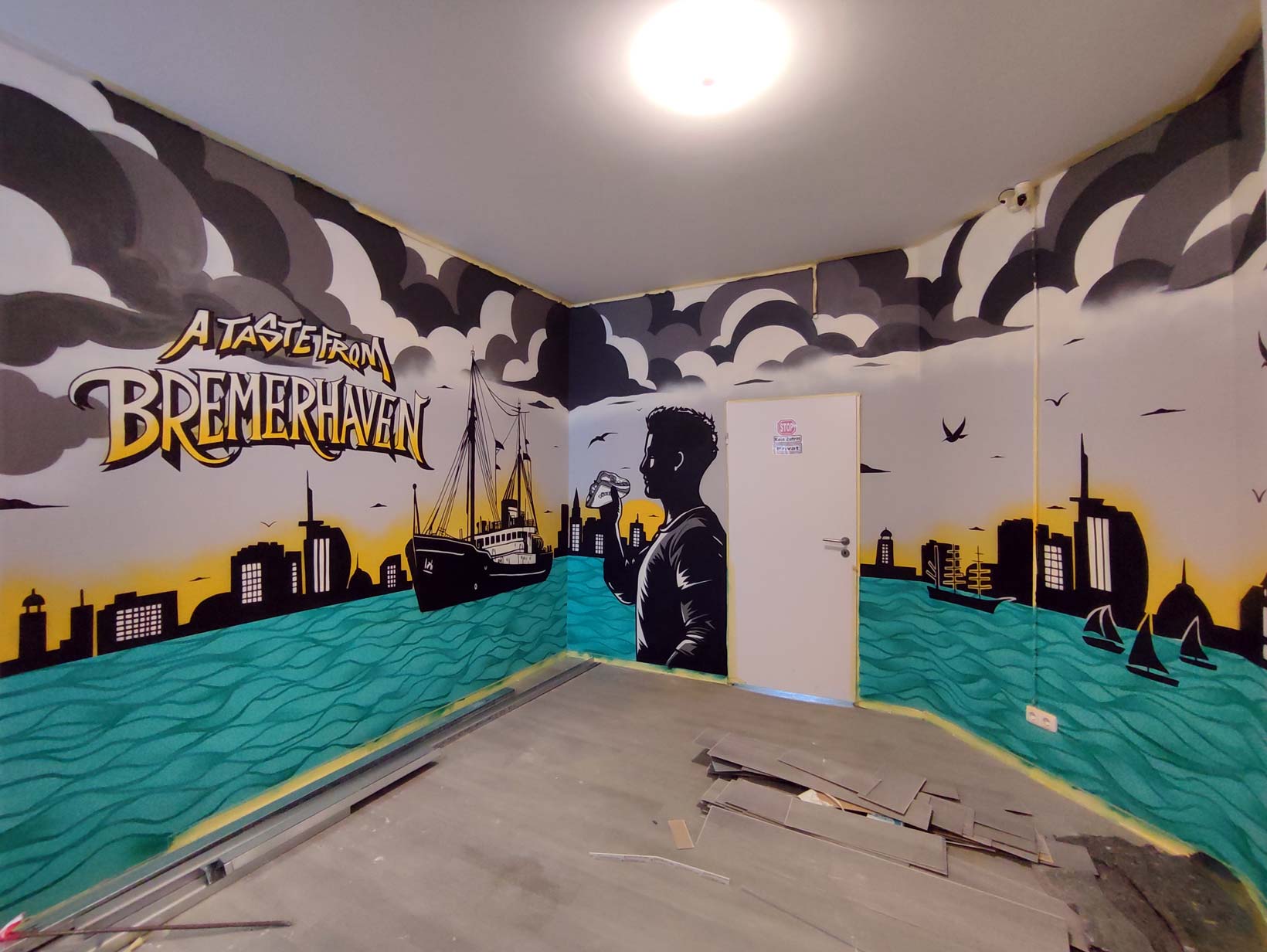 Buntes Auftragsgraffiti mit Schiffssilhouette und Skyline von Bremerhaven vor einem Sonnenuntergang und Wolken.