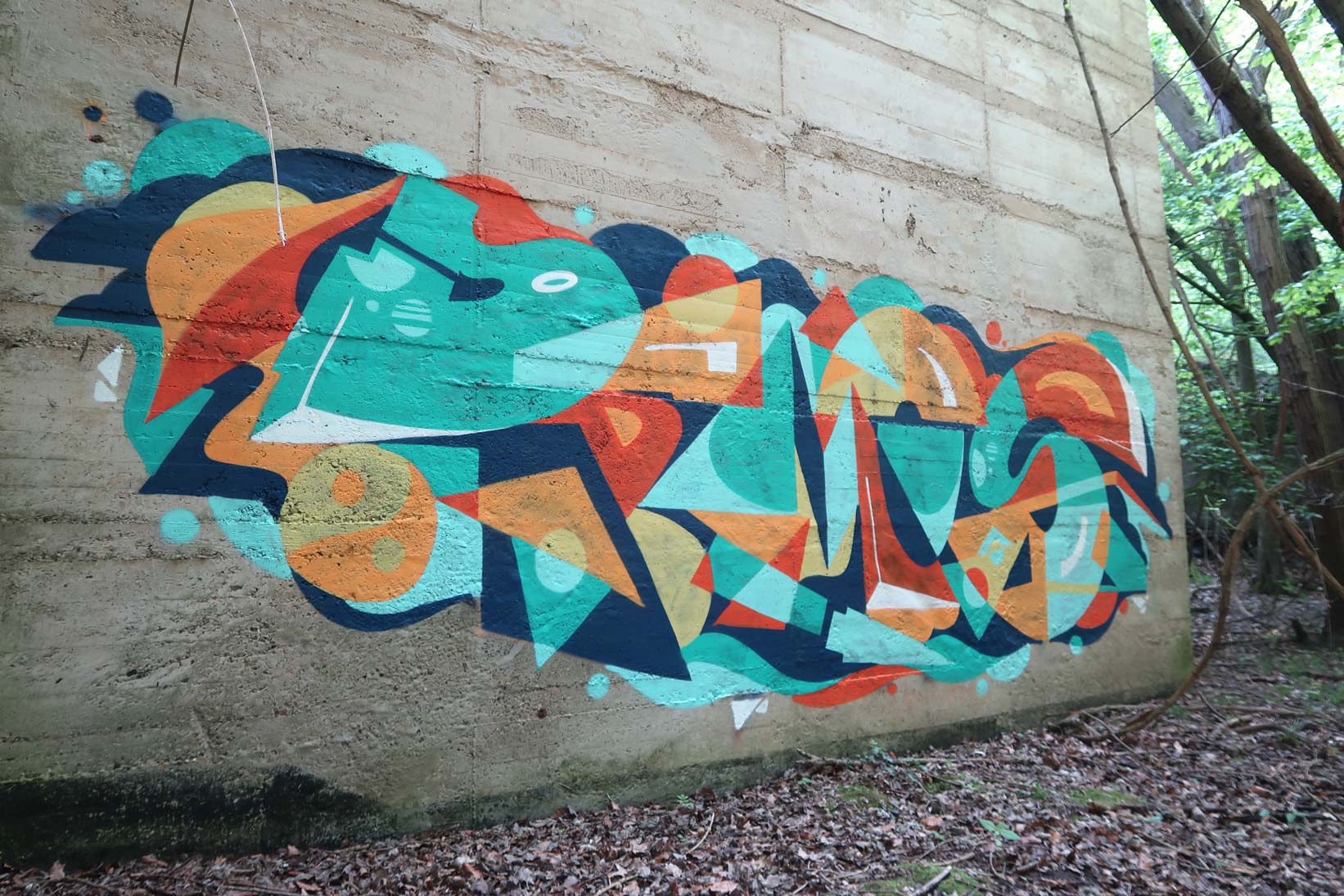 abstraktes-Graffiti-mit-grafischen-Formen,-knalligen-Farben-und-starken-Kontrasten auf einer Betonmauer